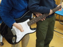 子どもたちがギターを弾いている写真