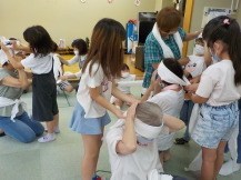 子どもたちが三角巾の使い方を実践している写真