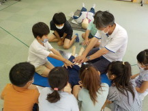 子どもたちが心臓マッサージを教わっている写真