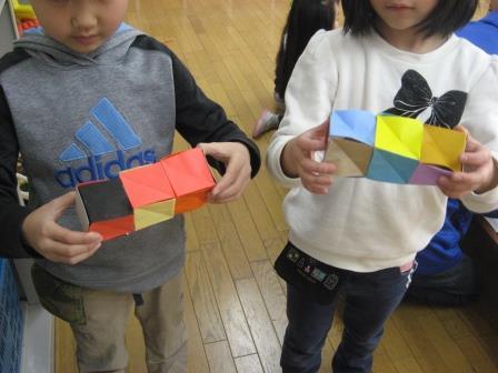 折り紙で作ったマジックキューブを持っている子どもたち