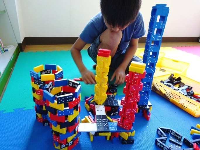 子どもがドミノで塔を作っている写真